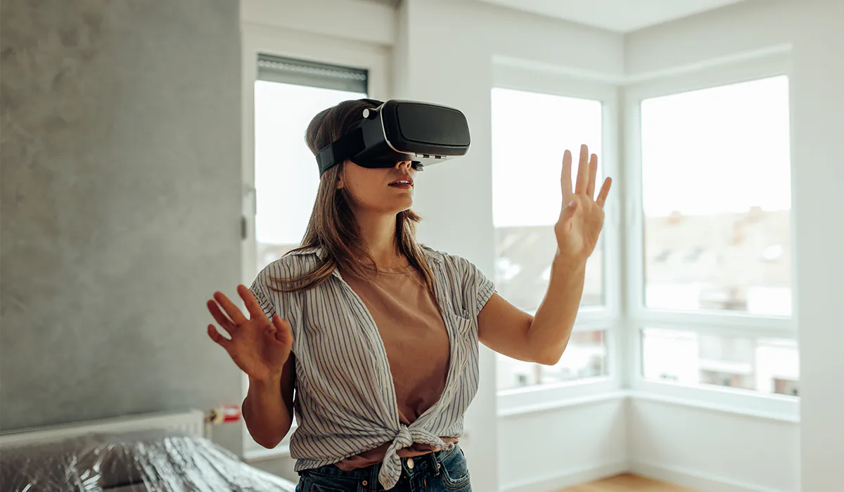 immobilien-rundgang-360-grad Frau mit VR-Brille erlebt virtuelle Wohnungsbesichtigung in lichtdurchflutetem Raum.